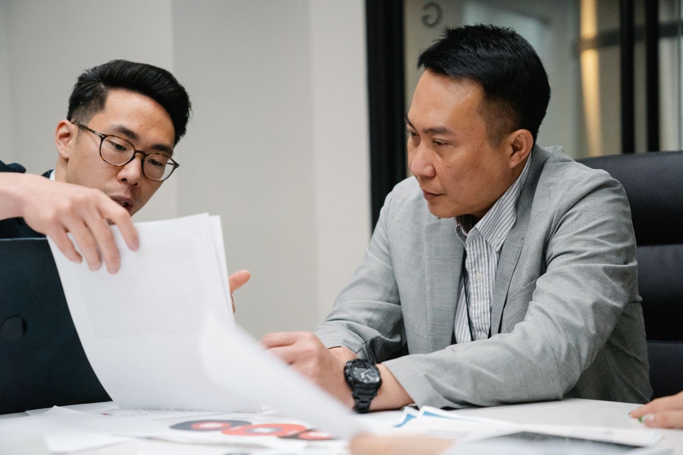Two colleagues discussing documents in an office