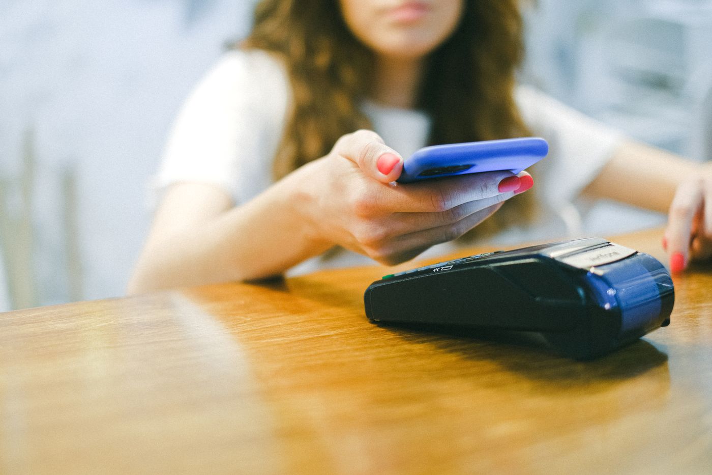 A customer paying by phone at a card terminal